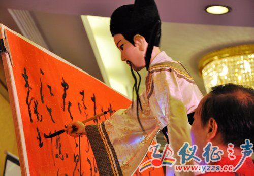 祝留根巧手拨弄木偶"李白,准备为宾朋吟诗题词.摄影:仪征之声 周晓明